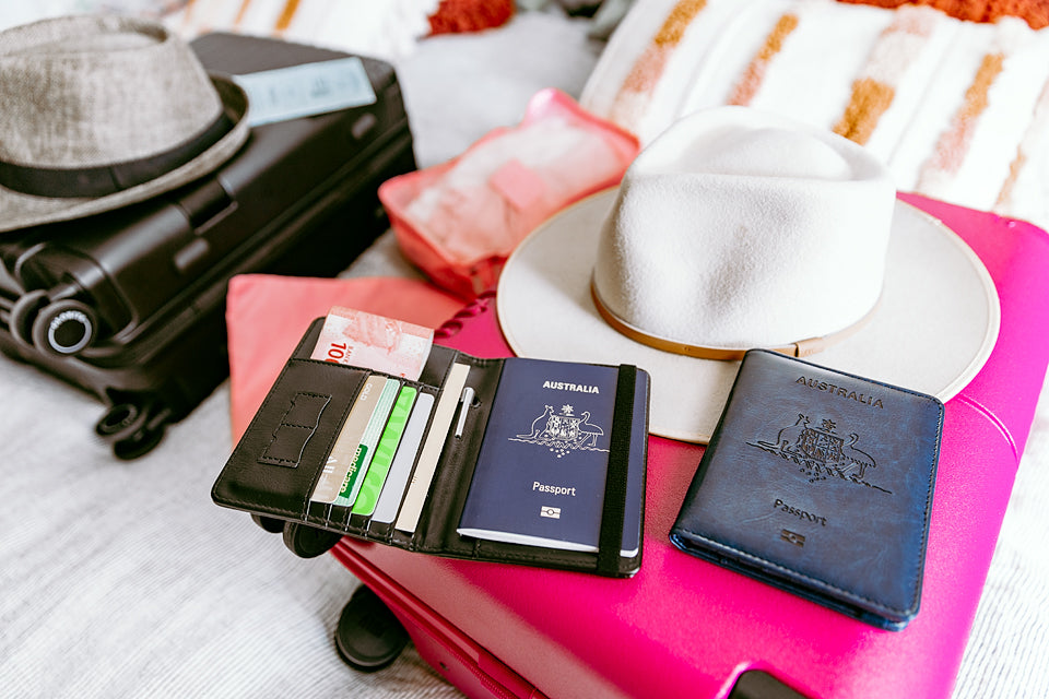 navy-and-black-travel-wallets-on-pink-suitcases